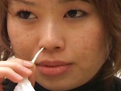 Japanese lady blows her nose onto a bunch of Kleenex tissues
